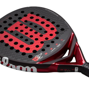 Angled close-up of a black and red padel racket with a textured face, red Wilson W logo, and Bela Pro on the throat.