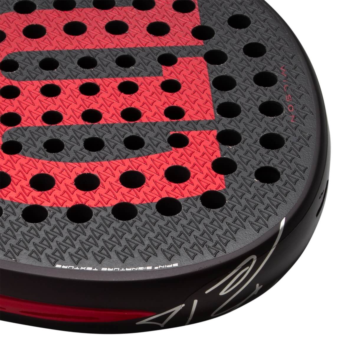 Close-up of a black and red padel racket with a textured surface, circular holes, and a red W and WILSON text.