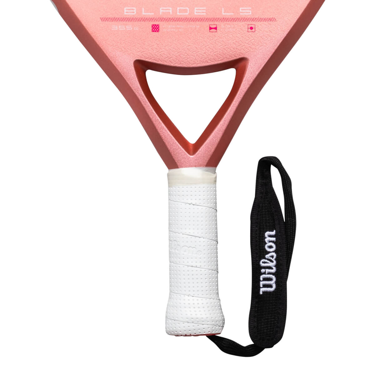 Close-up of a pink pickleball paddle showing "BLADE LS" and a white grip with a black Wilson wrist strap.