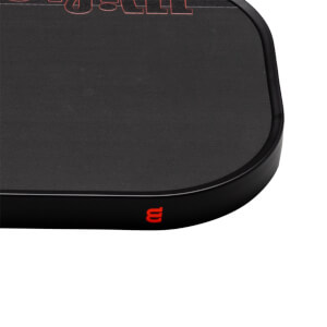 Close-up corner view of a matte black pickleball paddle featuring a red Wilson logo on the edge guard and red "STAFF" text on the face.