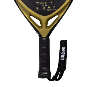 Close-up of a black and gold padel racket showing a perforated grip, gold throat with DEFY LS, and Wilson wrist strap.