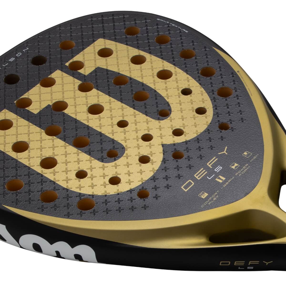 Angled close-up of a black and gold padel racket with a large gold W logo, Defy LS text, and small holes.