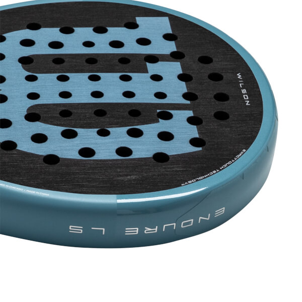 Corner view of a blue padel racket with black holes and the "WILSON" logo.